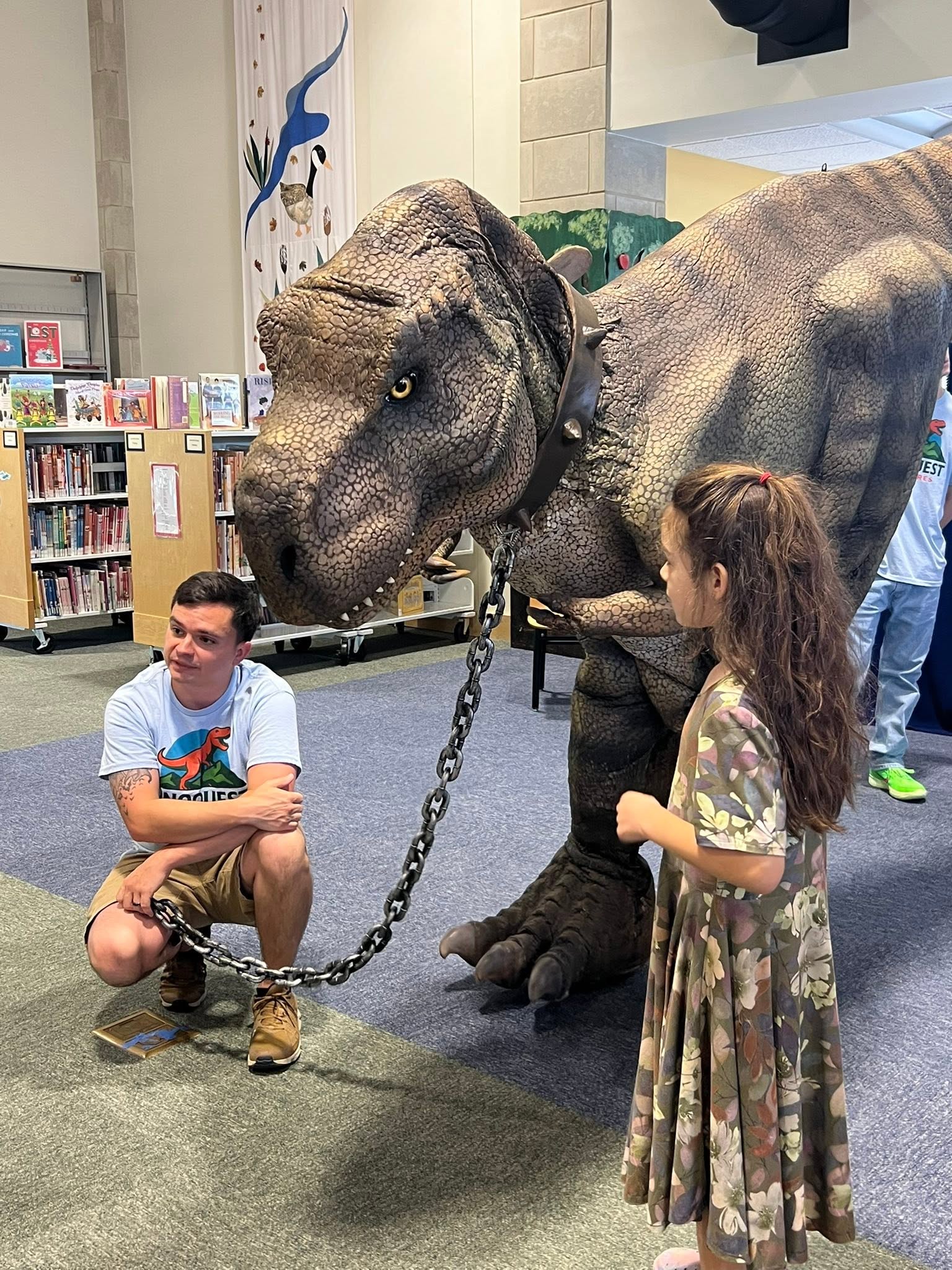 Girl with dinosaur at a library